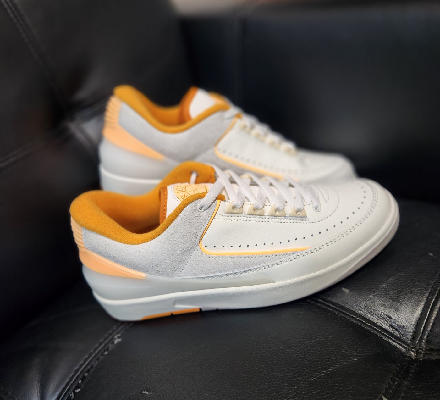 Air Jordan 2 Retro Low Craft Melon Tint off-white sneakers with orange accents on tongue, heel, and outsole, SKU DV8759-600